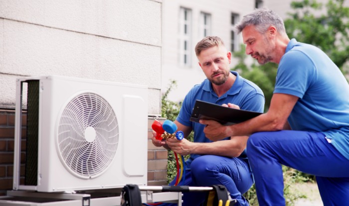 HVAC technicians reviewing an outdoor air conditioning unit in Casa Grande, AZ