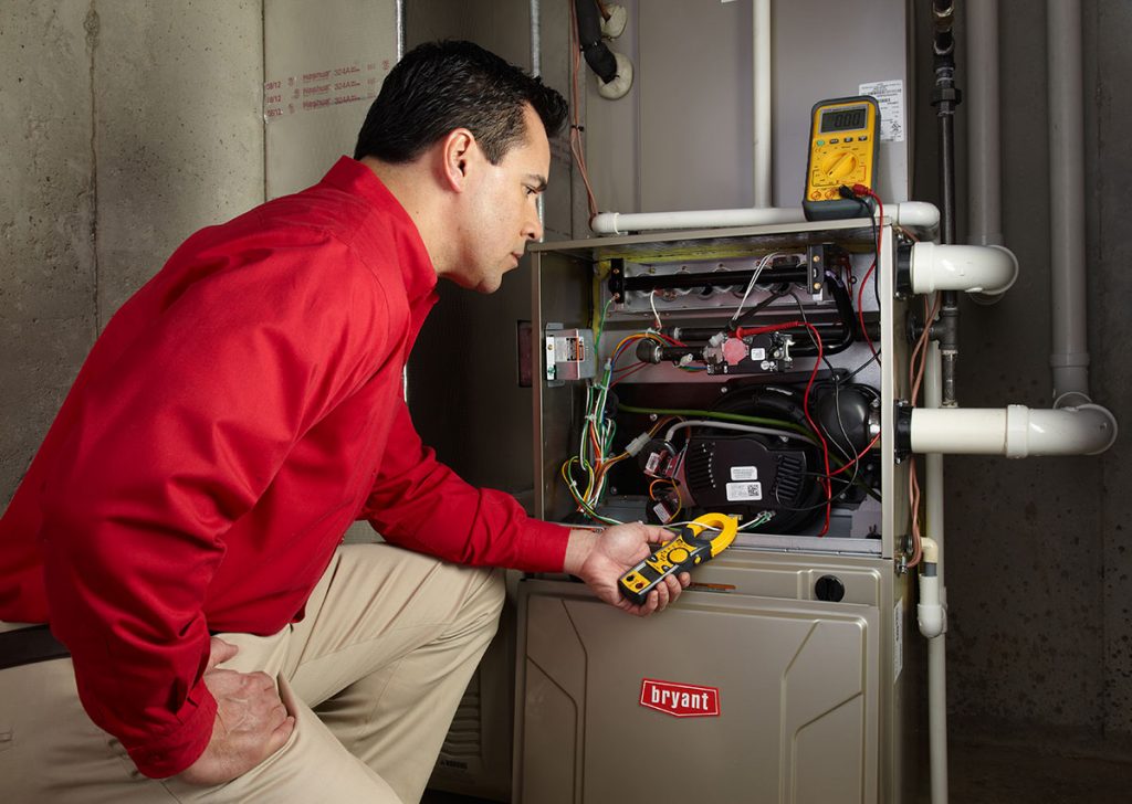 Heating and air conditioning technician servicing an indoor furnace in Casa Grande, AZ