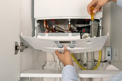 HVAC technician repairing an indoor boiler in Casa Grande
