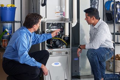 HVAC technician explaining furnace repair and maintenance to a homeowner in Casa Grande, AZ