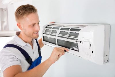 HVAC technician cleaning and repairing a ductless mini split AC in Casa Grande, AZ
