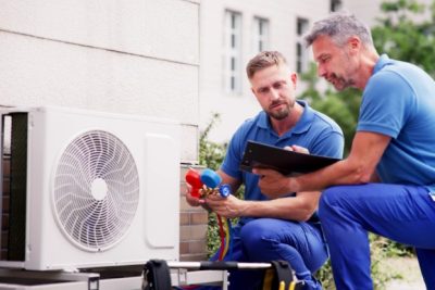 HVAC technicians reviewing an outdoor air conditioning unit in Casa Grande, AZ