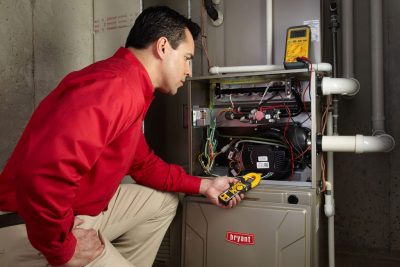 Heating and air conditioning technician servicing an indoor furnace in Casa Grande, AZ